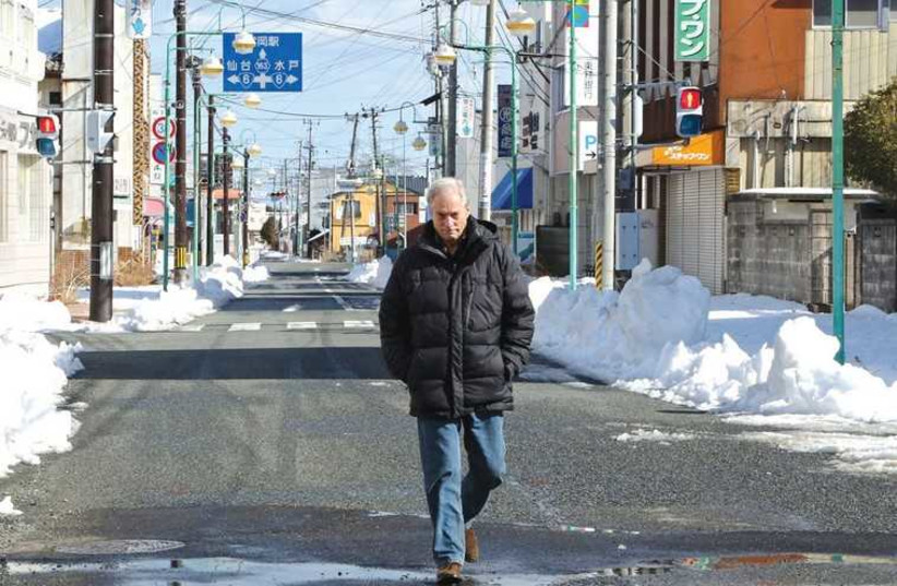 CBS NEWS correspondent Bob Simon walks through the town of Tomioka, Japan, three years after the 2011 Fukushima disaster. ( (photo credit: REUTERS)