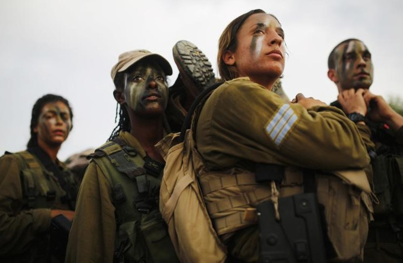 Israeli soldiers of the Caracal battalion carry their comrade on a stretcher during a 20-kilometer march in Israel's Negev desert, near Kibbutz Sde Boker (photo credit: REUTERS)