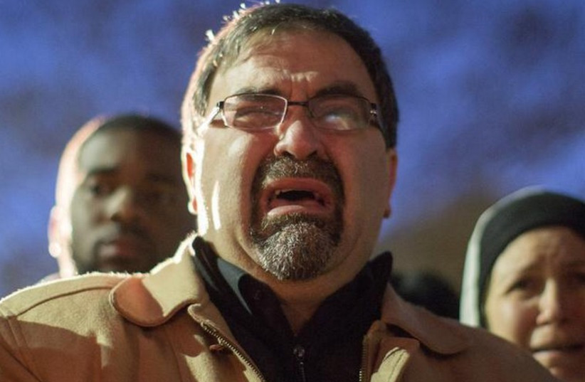 Namee Barakat, father of shooting victim Deah Shaddy Barakat, cries as a video is played during a vigil on the campus of the University of North Carolina in Chapel Hill, North Carolina (photo credit: REUTERS)