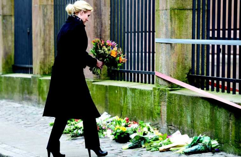 La Première ministre danoise Helle Thorning-Schmidt dépose des fleurs devant la synagogue Krystalgade de Copenhague (photo credit: FABIAN BIMMER / REUTERS)