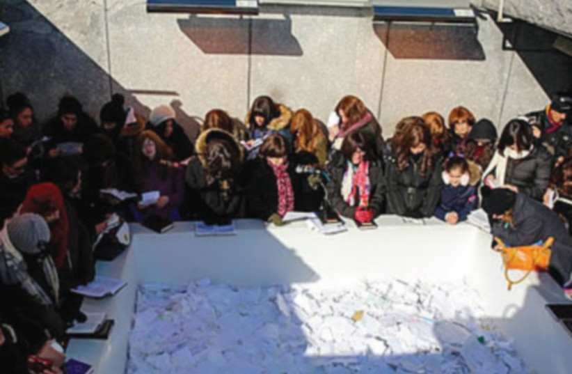 WOMEN PLACE notes at the resting place of Rabbi Menachem M. Schneerson in Queens, New York, last week. (photo credit: CHABAD.ORG)