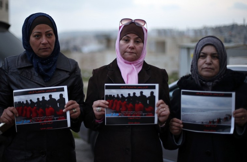 Women hold up pictures of the 21 Egyptian Coptic Christians beheaded by Islamic State in Libya, as they gather in a gesture to show their solidarity, in Amman (photo credit: REUTERS)