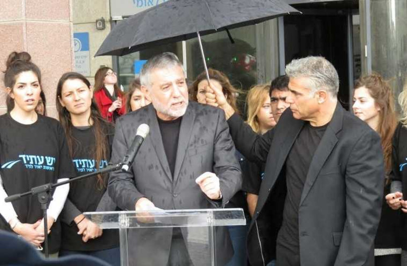 Yair Lapid and former Welfare Minister Meir Cohen present Yesh Atid's social welfare platform outside of the National Insurance Institute in Tel Aviv on Wednesday (photo credit: Courtesy)