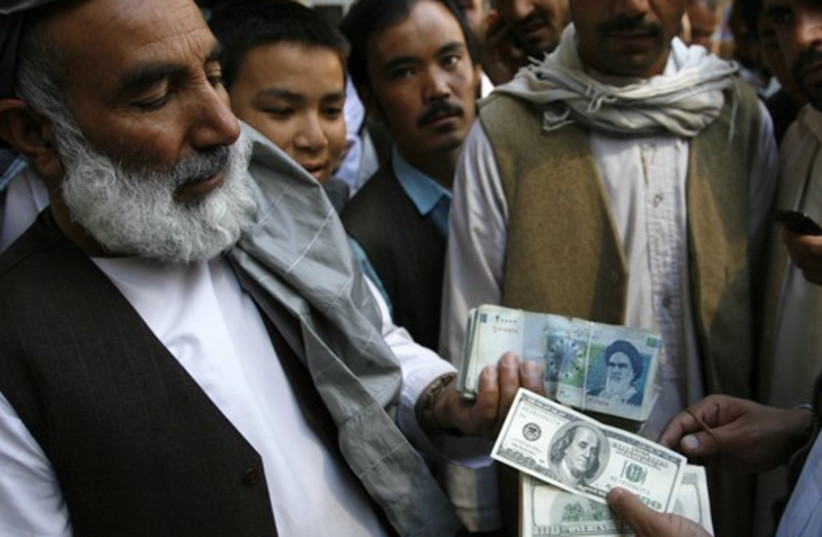 Afghan money lenders trade Iranian rial for dollars (photo credit: REUTERS)