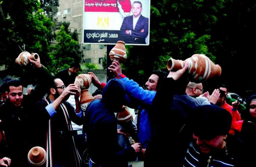 Des Egyptiens en colère cassent de la poterie lors d'une manifestation devant l'ambassade qatarie du Caire, le 21 février dernier. L'Egypte a, après le rappel de son ambassadeur, accusé le Qatar de soutenir le terrorisme  (photo credit: REUTERS)