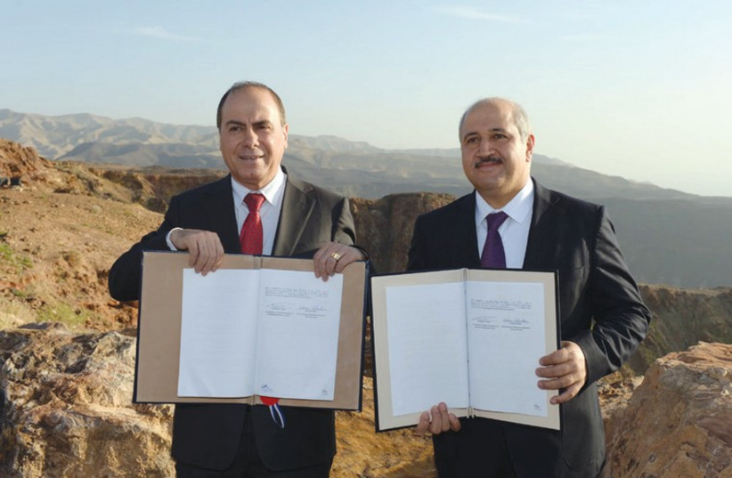 NATIONAL INFRASTRUCTURE, Energy, and Water Minister Silvan Shalom (left) and his Jordanian counterpart, Water and Irrigation Minister Hazim el-Naser, display the agreement yesterday after signing on the eastern side of the Dead Sea (photo credit: HAIM ZACH/GPO)