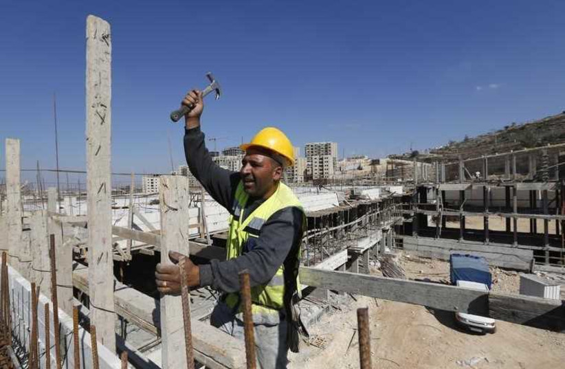 A Palestinian laborer works on a construction site in the new Palestinian town dubbed Rawabi or "The Hills", near the West Bank city of Ramallah (photo credit: REUTERS)