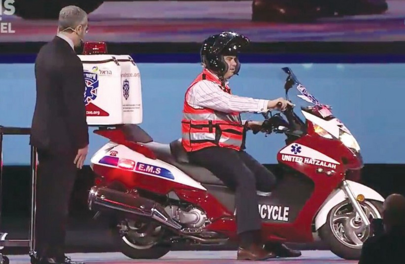 Eli Beer, the founder and president of United Hatzalah, arrives onstage on an ambucycle at the AIPAC conference in Washington (photo credit: UNITED HATZALAH‏)