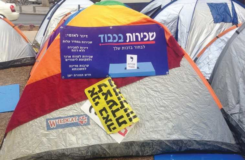  A SIGN DEMANDING fair housing solutions hangs on a tent on Rothschild Boulevard in Tel Aviv yesterday. (photo credit: NIV ELIS)