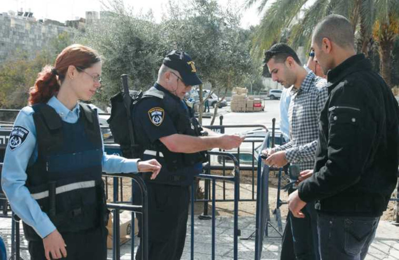 Border police check Palestinian IDs at the entrance to Jerusalem’s Old City. (photo credit: MARC ISRAEL SELLEM/THE JERUSALEM POST)