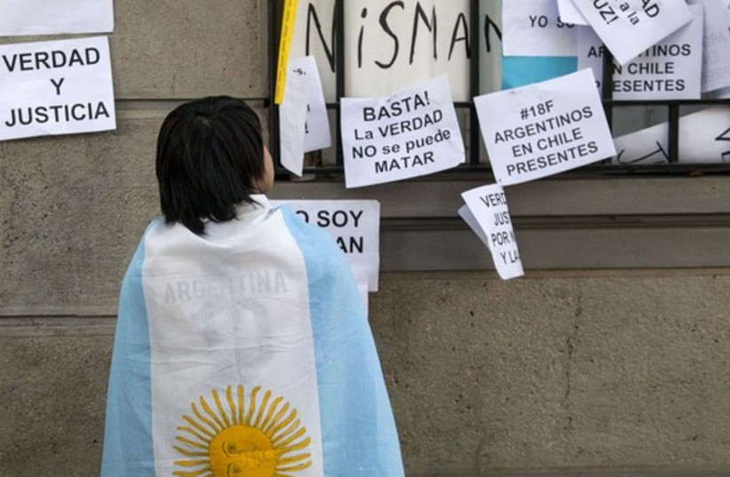 A citizen wears an Argentina flag during a peaceful demonstration honouring late Argentine state investigator Alberto Nisman outside the Argentina Embassy in Santiago (photo credit: REUTERS)