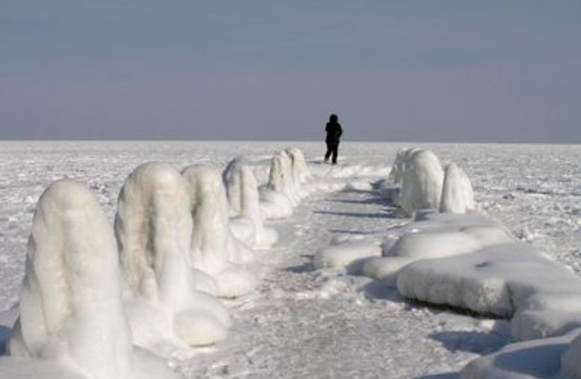 woman walks on a pier on the frozen Black sea in the Ukraine