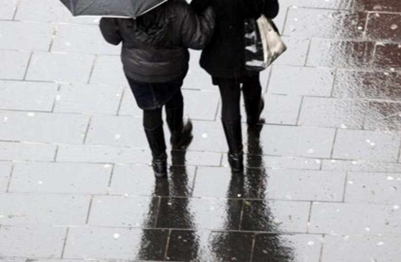 Two women stroll in the rain in Jerusalem