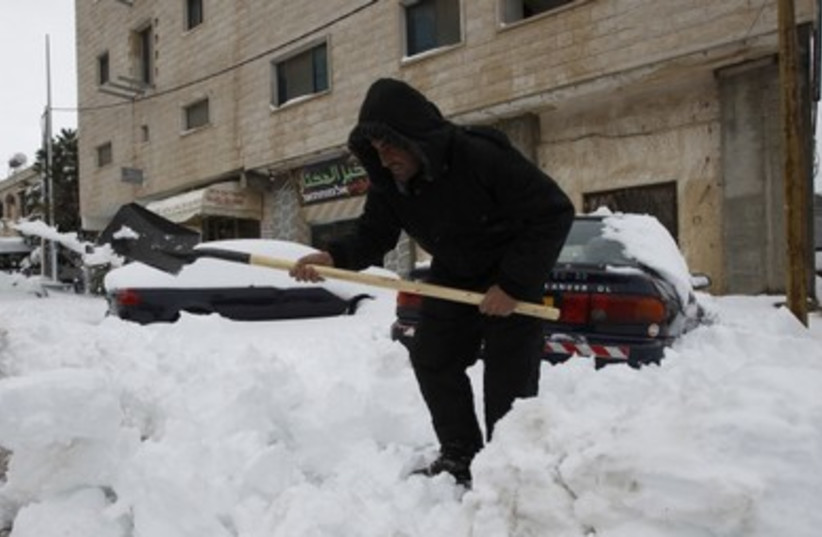 Druse man shovels snow in Majddal Shams