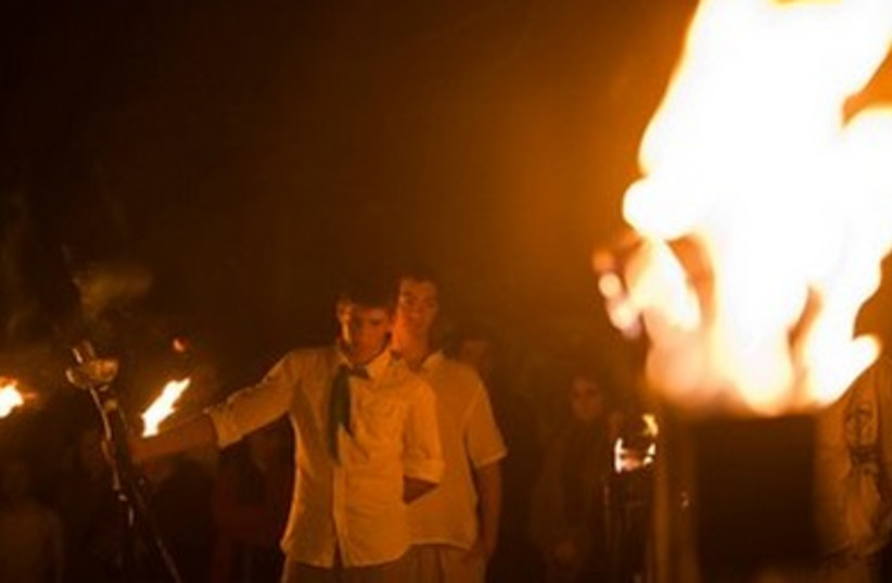 Scout holds torch at Mount Herzl