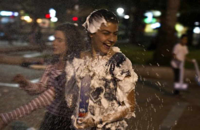 Israeli girls play with foam spray
