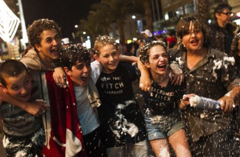 Israelis play with foam spray
