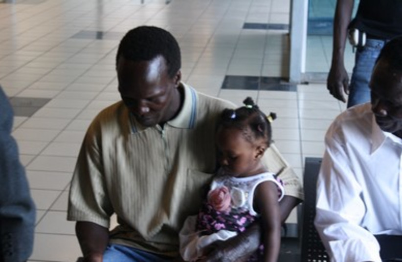 South Sudanese man holds daughter in Tel Aviv 