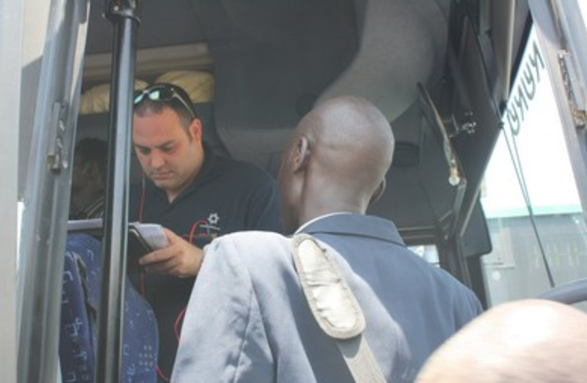 Migrants board bus in preparation for flight to Juba