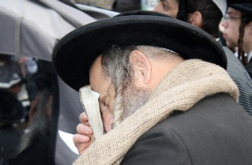 Haredi man prays at protest