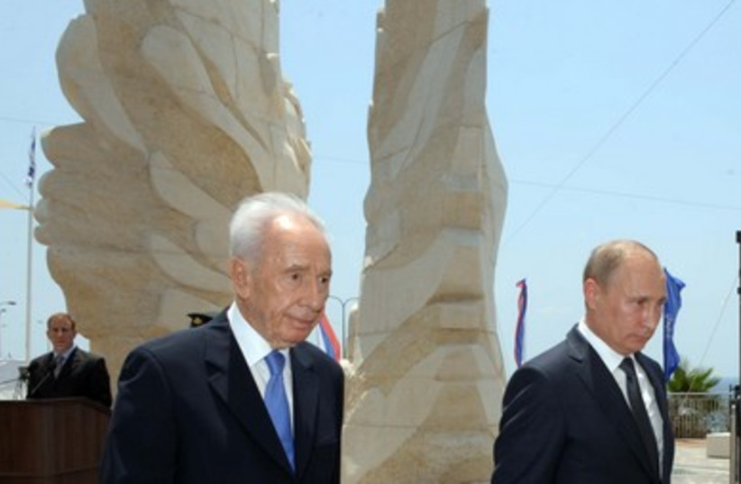 Peres walks with Putin in front of Red Army monument