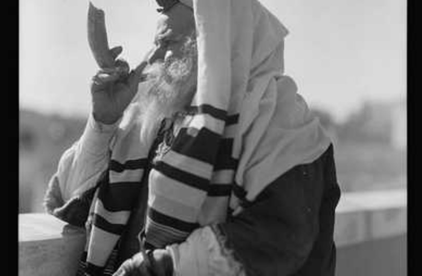 Yemenite Rabbi Avram, donning tfillin for his daily prayers,
