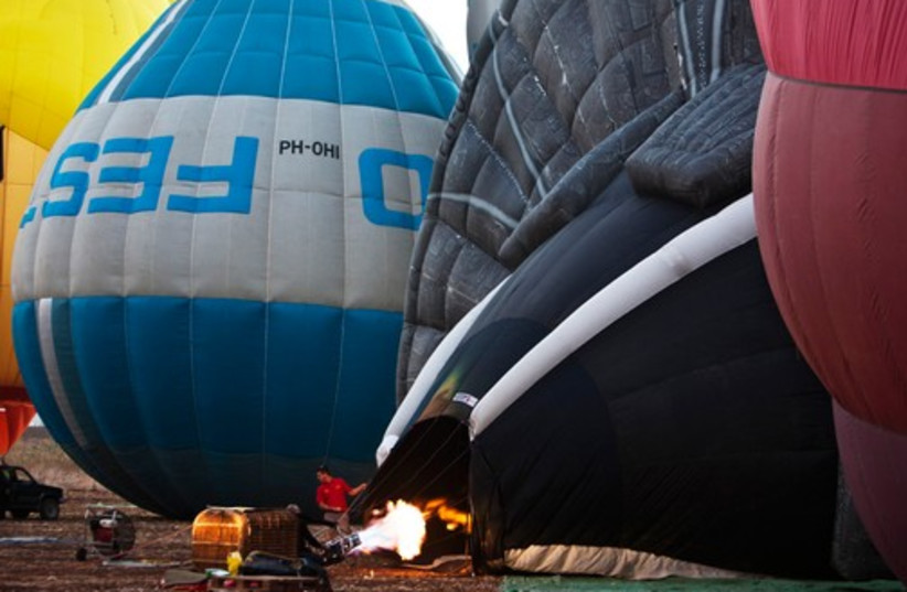 Men prepare a hot air balloon before it takes flight 