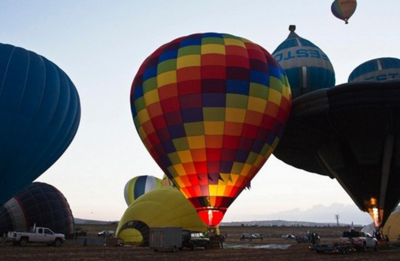 Hot air balloons are prepared before they take flight .
