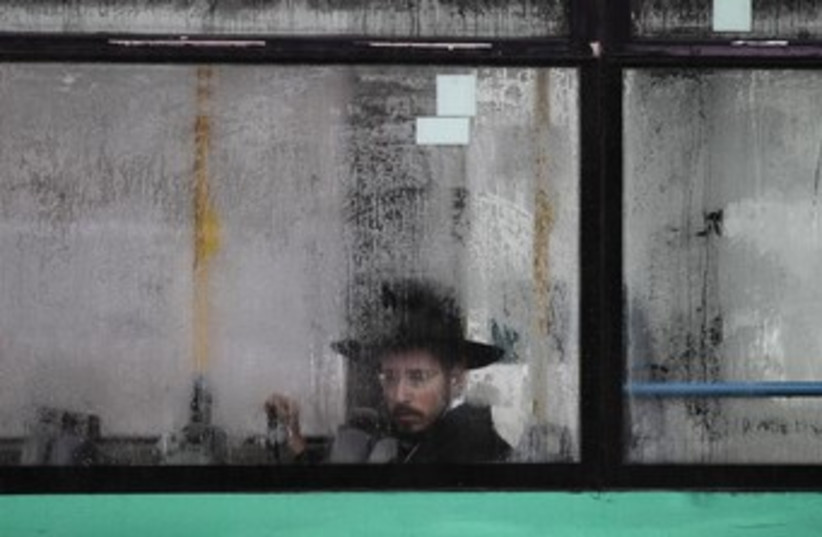 A bus passenger looks out at rain-drenched Jerusalem 370