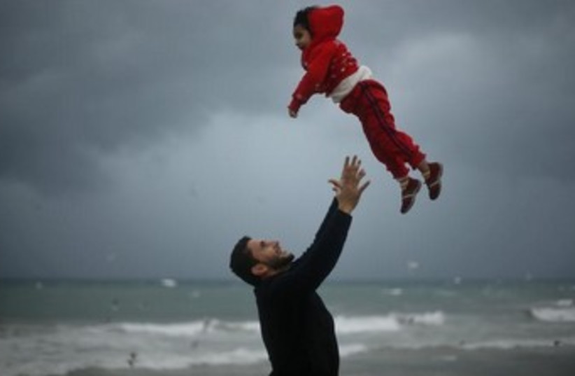 A Palestinian and his daughter frolic on the beach in Gaza 