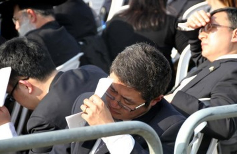Diplomates shield themselves from the sun at Ariel Sharon's funeral, January 13, 2014.