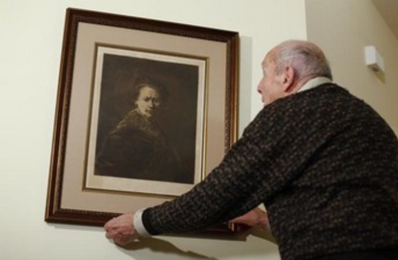 Harry Ettlinger a former member to the ''Monuments Men'' with a print of a Rembrandt self-portrait. (credit: REUTERS)