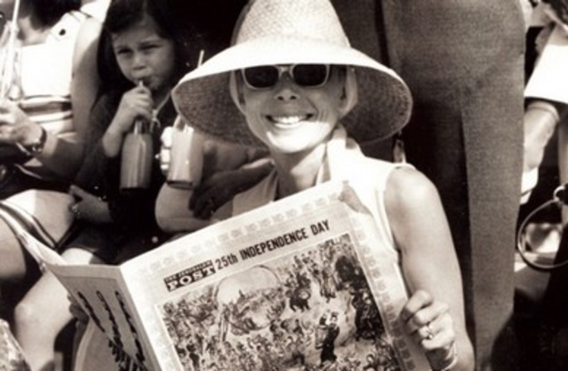 A WOMAN holds a copy of ‘The Jerusalem Post’s Independence Day Supplement during a celebration of the country’s 25th year.