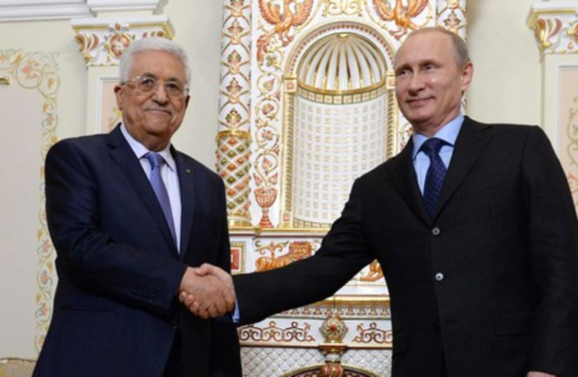 Russian President Vladimir Putin (R) shakes hand with PA President Mahmoud Abbas at the Novo-Ogaryovo state residence outside Moscow, June 25, 2014. (credit: REUTERS)