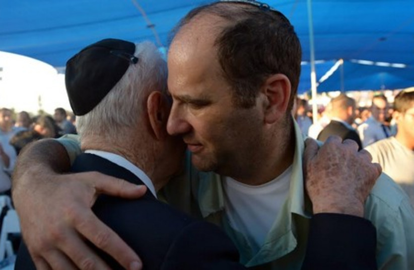 President Shimon Peres hugs the father of Naftali Fraenkel