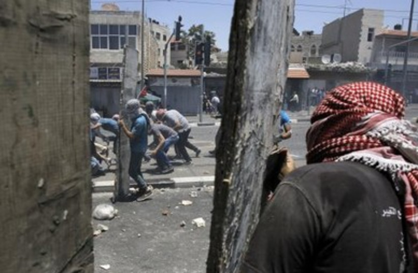 Palestinian stone-throwers clash with Israeli police in Shuafat.