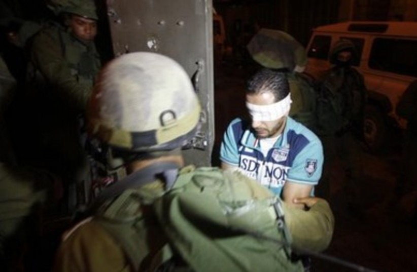 IDF soldiers detain a blindfolded Palestinians in Hebron.