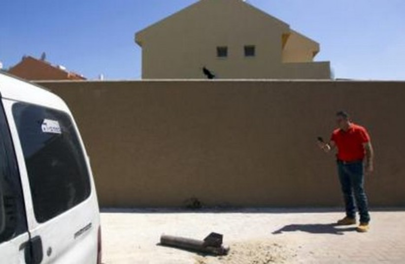 A neutralised Gaza rocket displayed by police after it landed in a house (back) in  Sderot July 3, 2014.