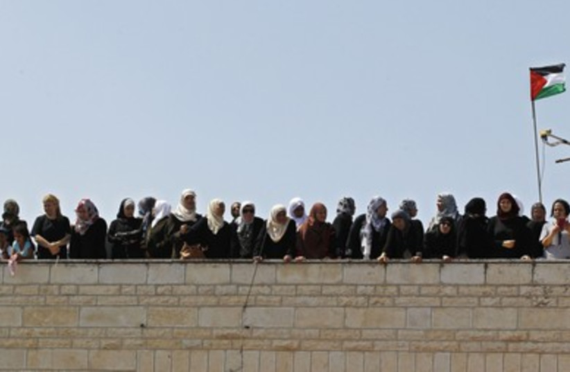 Palestinian women look on from the rooftop of a building during the funeral of 16-year-old Muhammad Abu Khdeir in Shuafat.