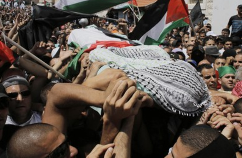 Palestinians carry the body of 16-year-old Muhammad Abu Khdeir during his funeral in Shuafat.