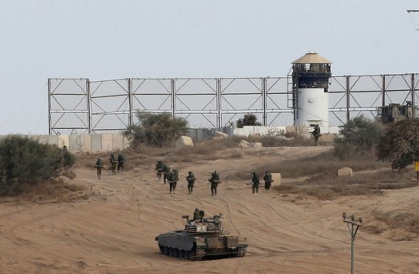 Israeli soldiers walk towards the border with Gaza Strip