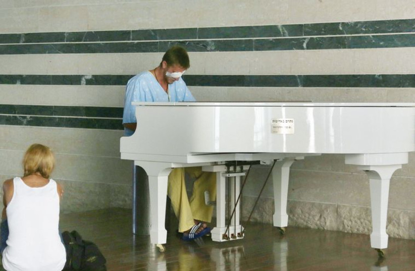 An IDF soldier, wounded in Operation Protective Edge, plays the piano at Beersheba’s Soroka University Medical Center