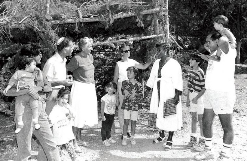 American and Ethiopian immigrants stand outside a succa in the Jerusalem Forest, erected by KKL-JNF, in 1992.
