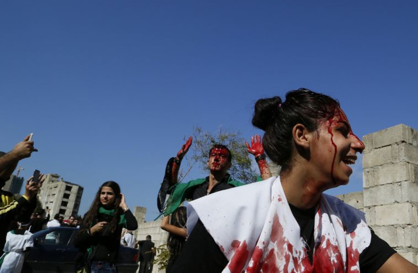 A Shi'ite Muslim girl marches with men, who are bleeding after tapping their foreheads with razors during the Ashoura ceremony held in Beirut.