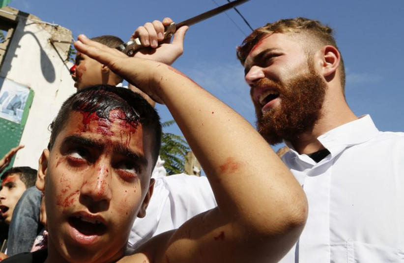 Shi'ite Muslims tap their heads during the Ashoura ceremony held in Beirut.