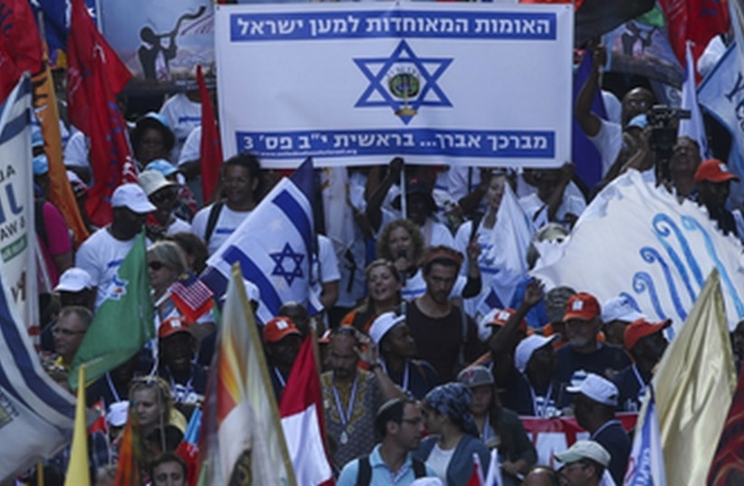 Evangelical Christians from around the world wave their national flags along with Israeli flags as they march in a parade in Jerusalem to mark the Feast of Tabernacles  (credit: JNS.ORG)