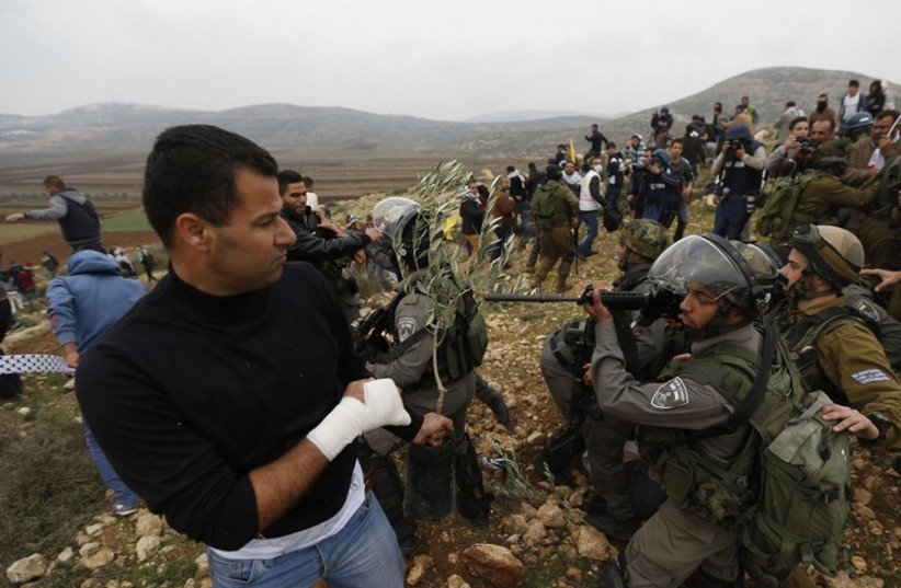 Israeli security forces and Palestinian protesters scuffle during clashes near Ramallah