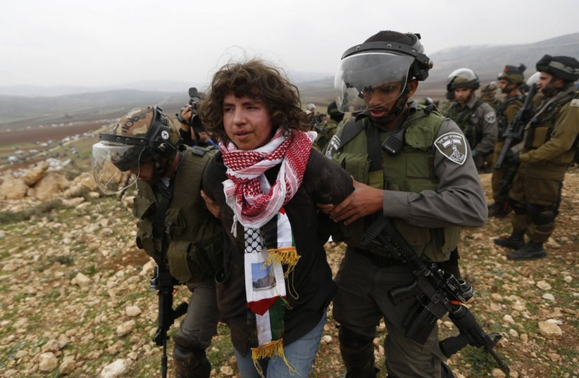 Israeli security forces arrest a foreign pro-Palestinian activist during clashes near Ramallah