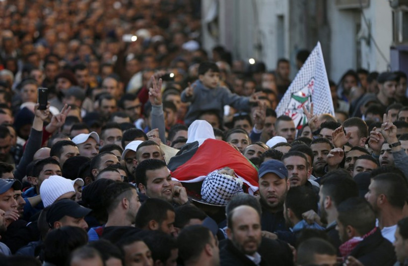 Mourners carry the body of Palestinian Mahmoud Adwan during his funeral in Qalandia refugee camp near the West Bank city of Ramallah on Tuesday 