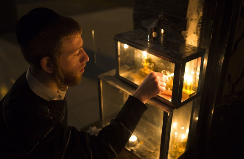 An ultra-Orthodox Jewish man lights a candle on the third night of the holiday of Hanukkah in the southern city of Ashdod